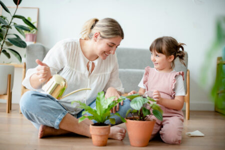 kid watering potted plants at home 450x300 1