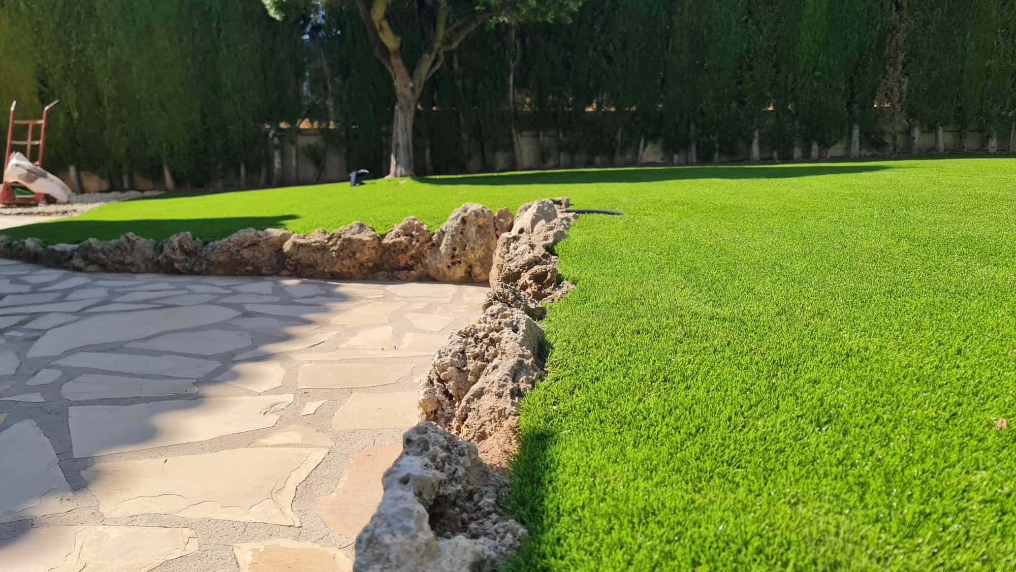 terraza con césped artificial y piedras